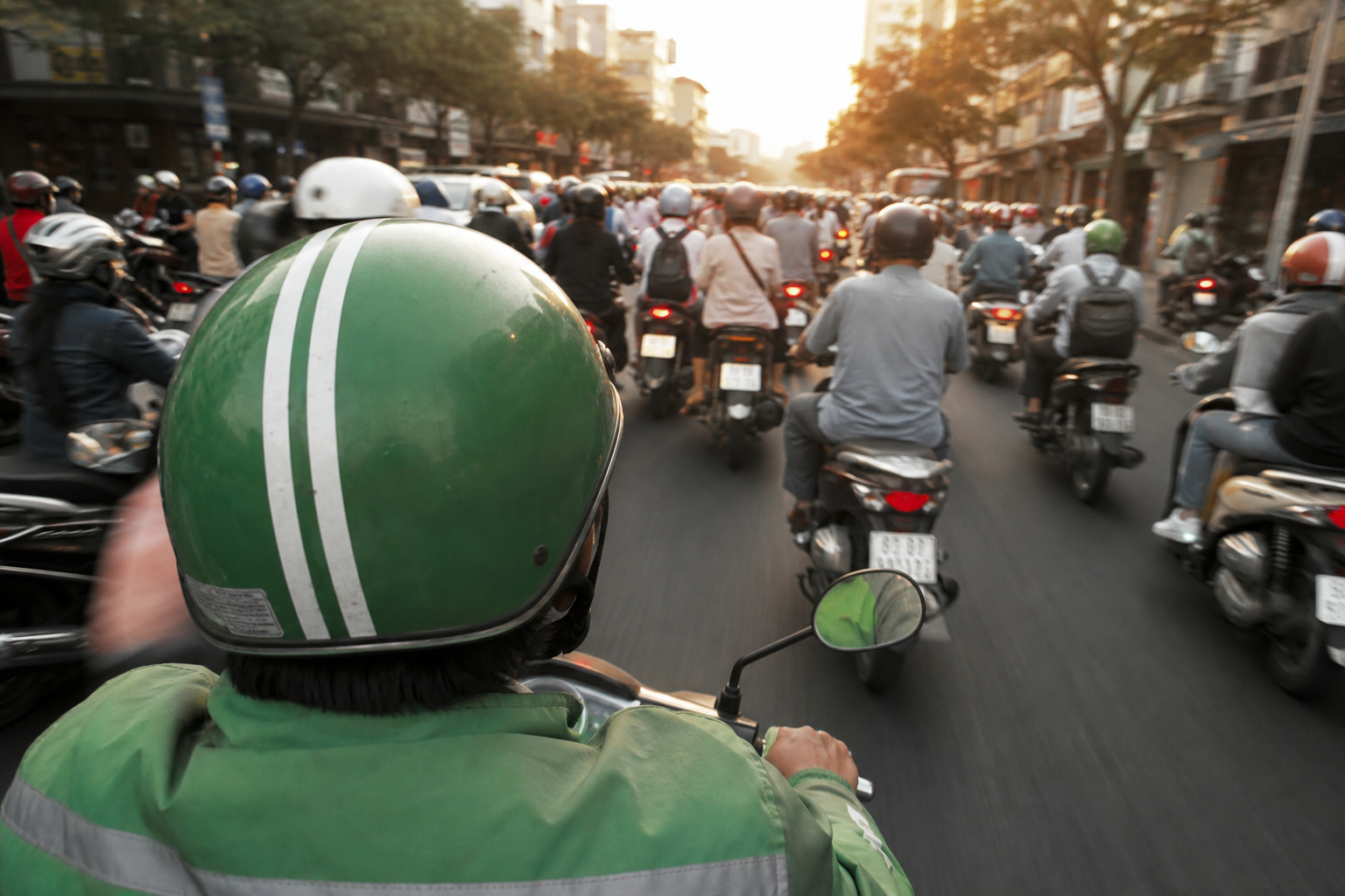 View from the back seat of a GrabBike motorbike taxi weaving through dense scooter traffic in Ho Chi Minh City