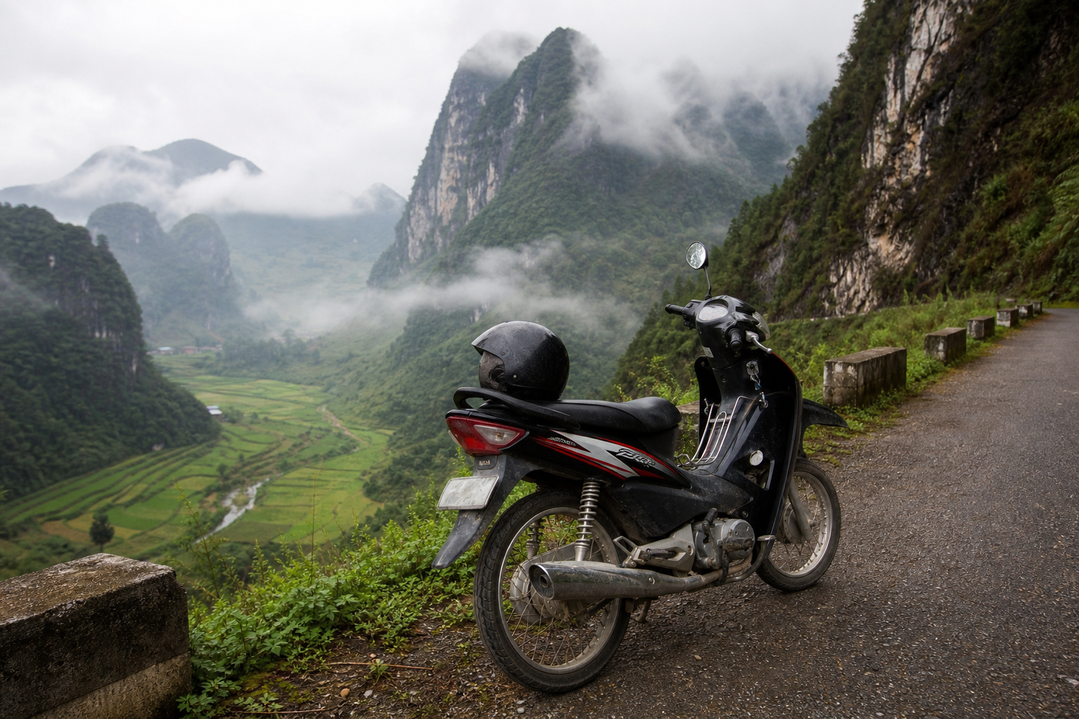 A rented semi-automatic motorbike parked on a mountain road in northern Vietnam with limestone karst peaks behind