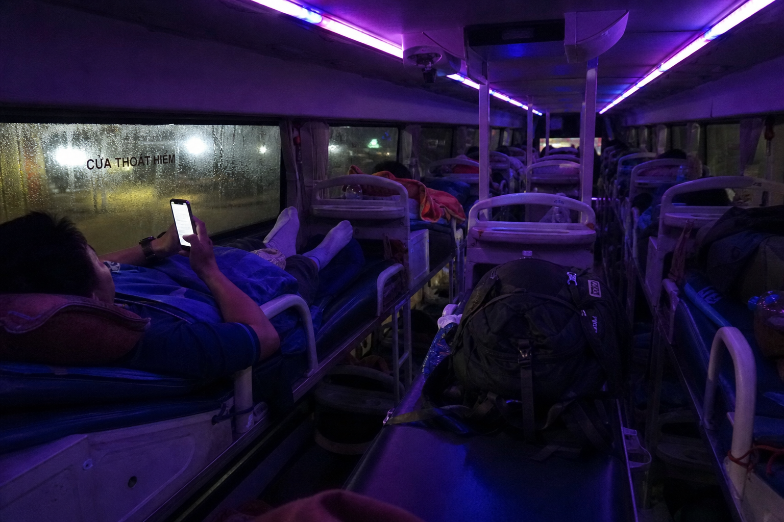 Inside a Vietnamese overnight sleeper bus with reclining berths and dim night lighting